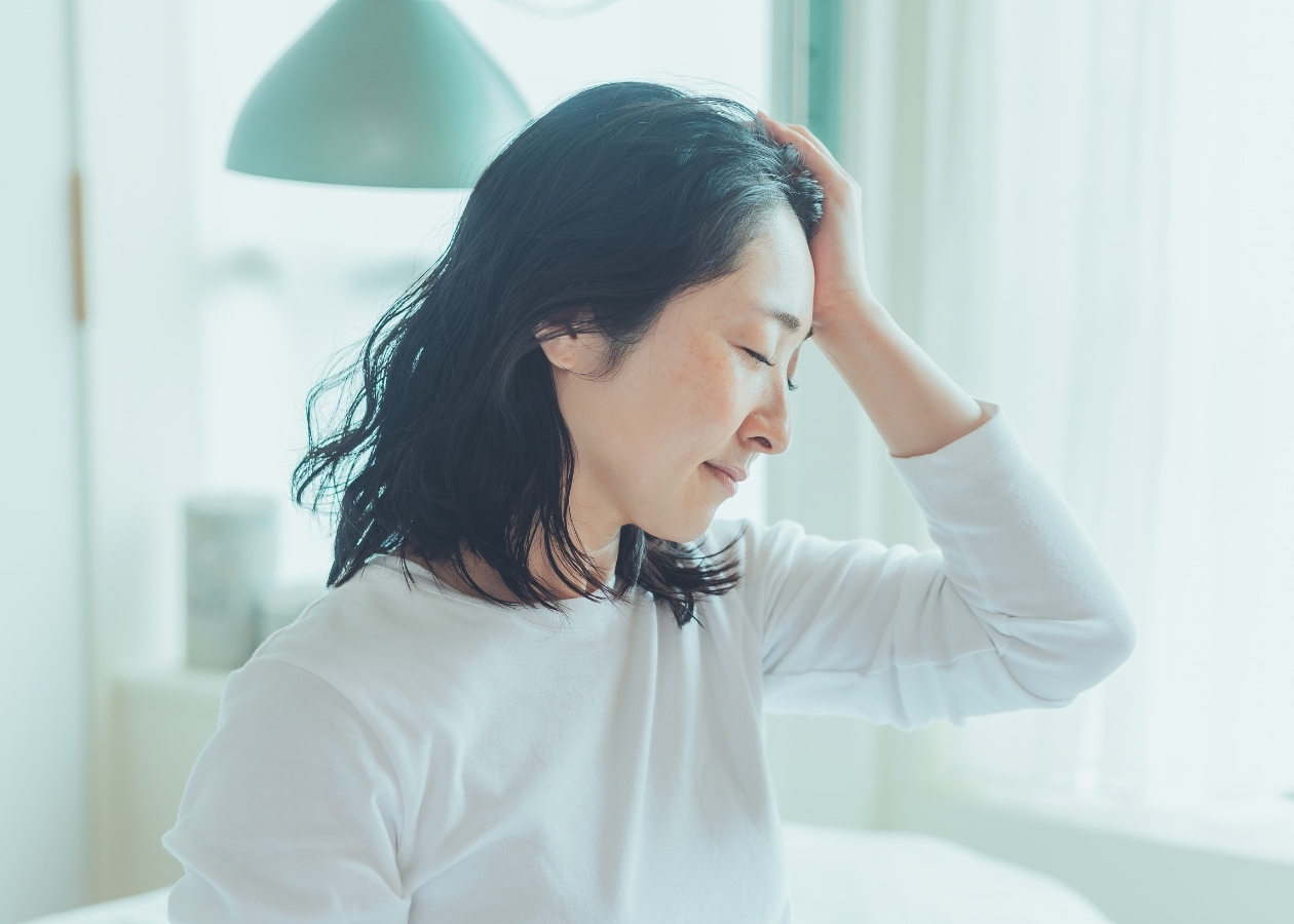 額をほぐす女性