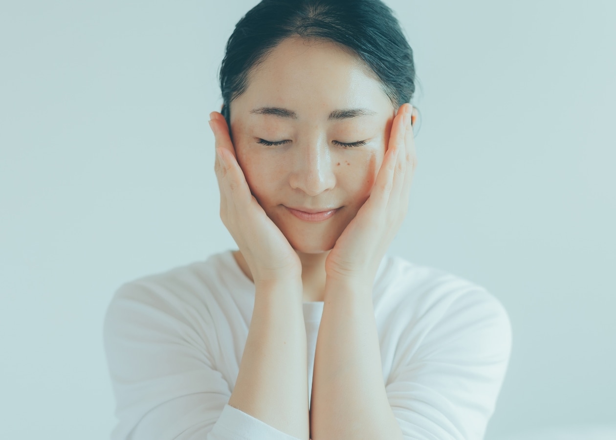 両手を顔にそえる女性