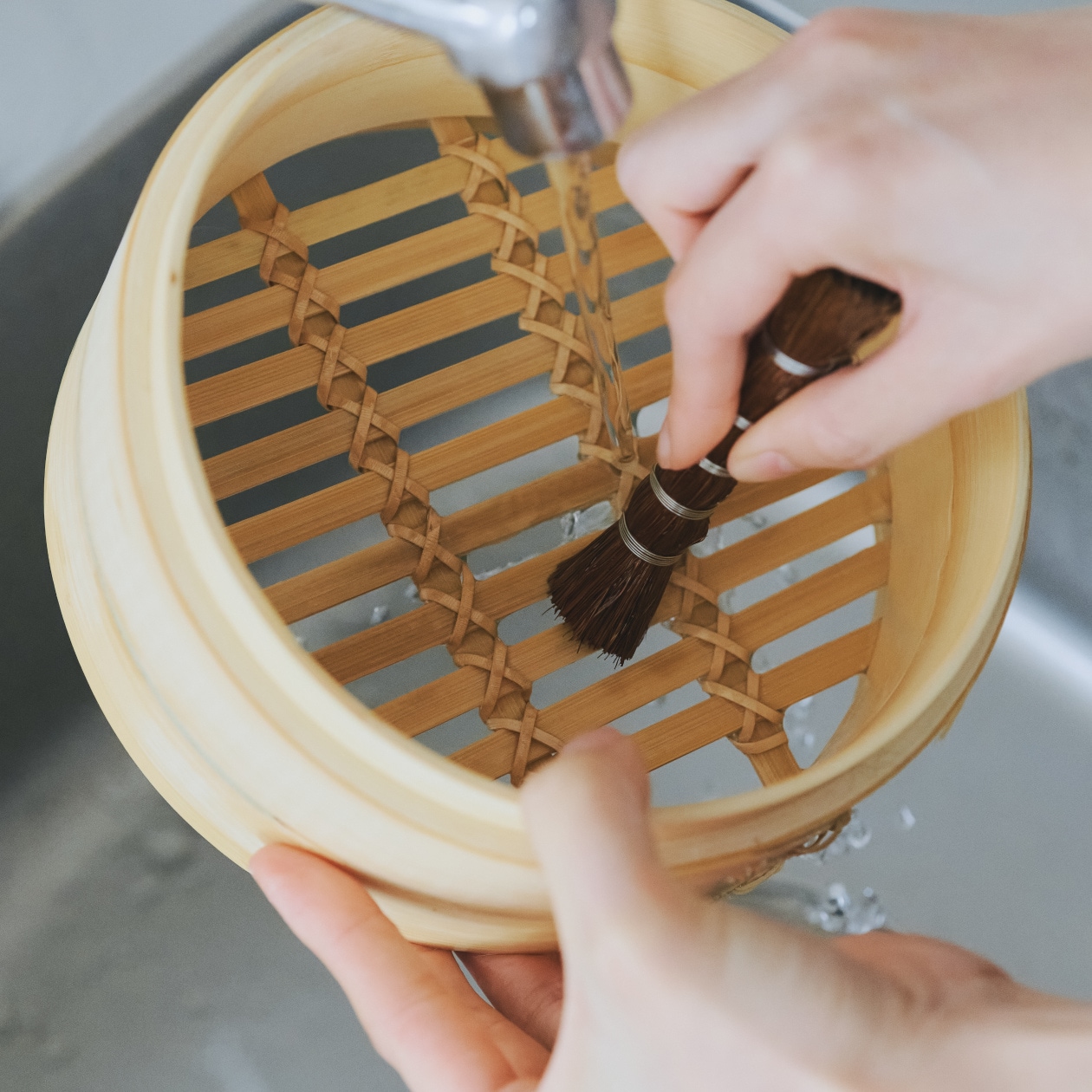 無印良品のせいろをシュロの棒たわしで洗う様子
