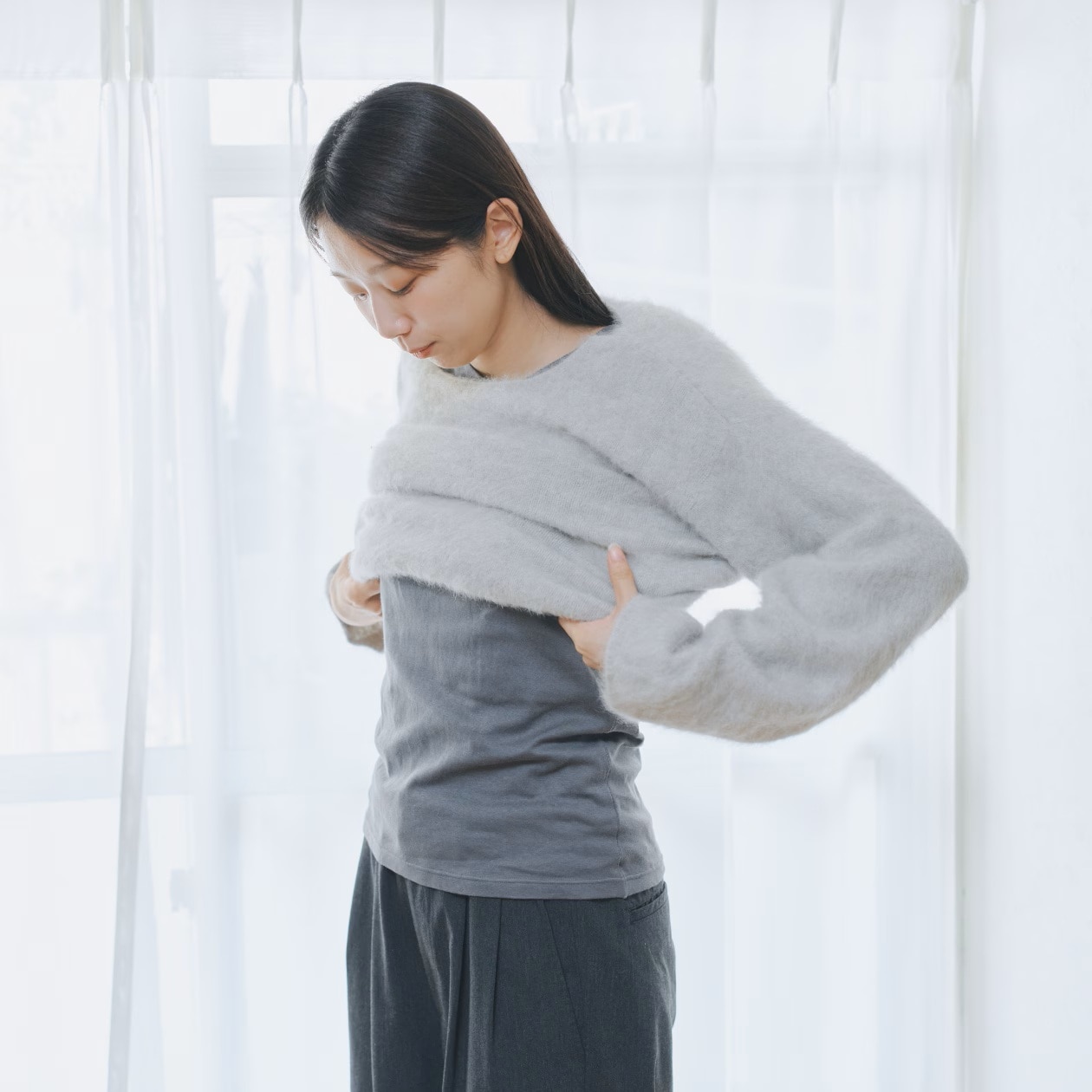 インナーの上にセーターを着る女性