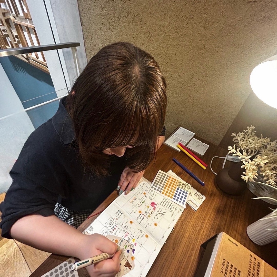 スケジュール帳に予定を書き込んでいる様子