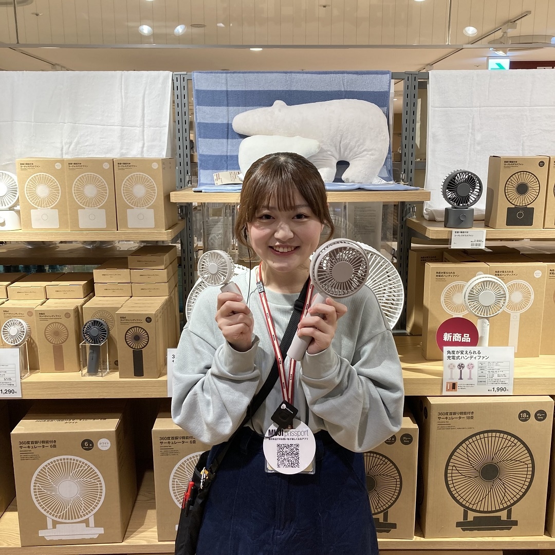 女性がハンディファンを持っている画像