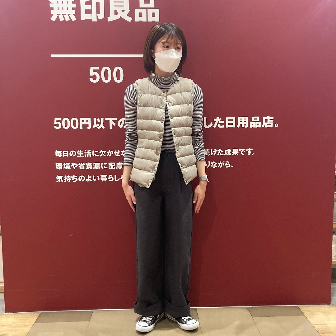 黒ボーダー長袖タートルネックTシャツにライトベージュのダウンベストを合わせたコーディネート