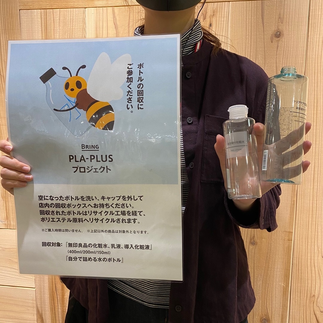 PLA_PLASプロジェクトのポスターと空きボトルを手に持った写真