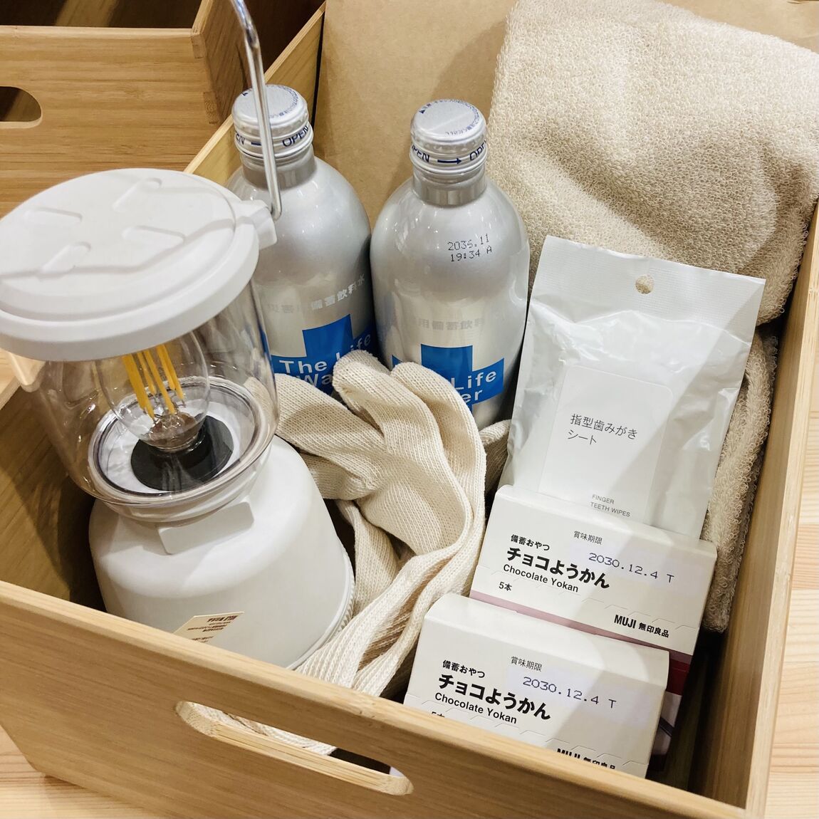 【テラスモール湘南】防災の準備セットをイメージした、竹の箱にタオルや長期保存飲料水、備蓄おやつ、ランタンなどを詰め込んだ写真