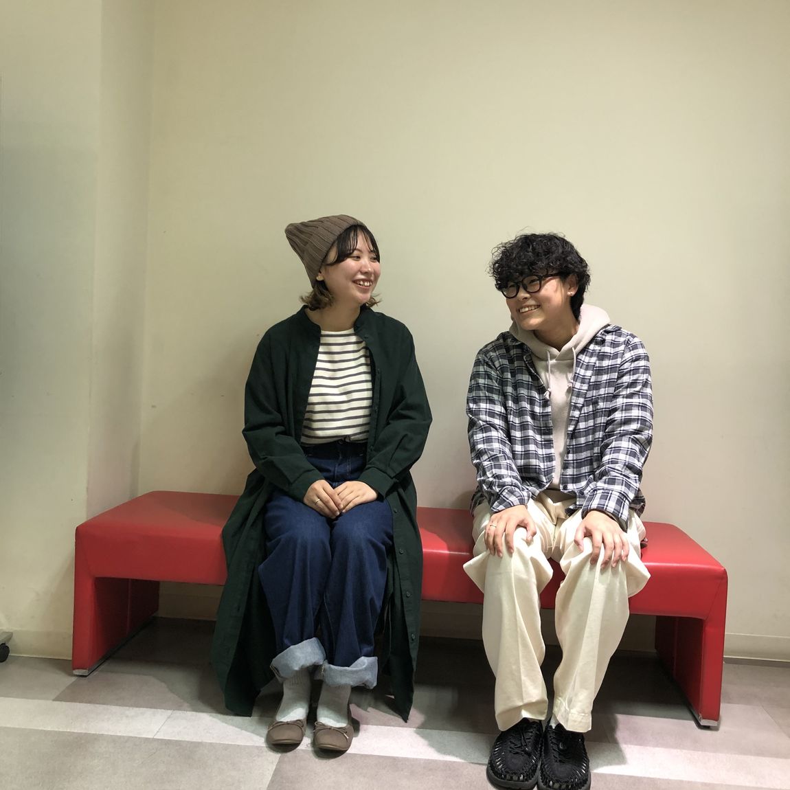 スタッフ2人がベンチに座っている写真