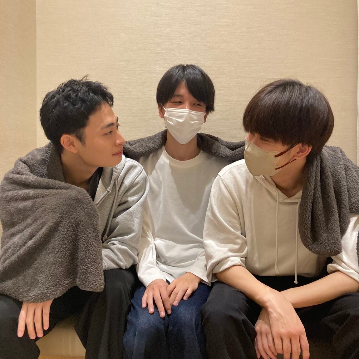 男性スタッフ3人が毛布を分け合っている