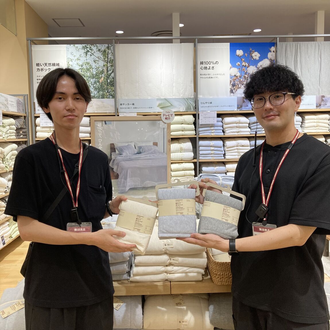 スタッフ2人が寝具を持っている写真