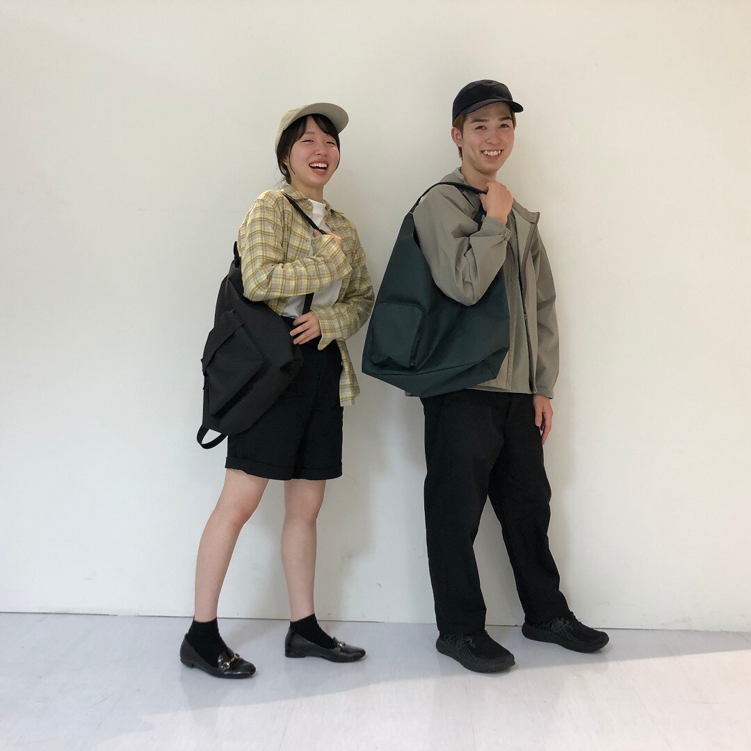 撥水ワンショルダーバッグと巾着リュックを持っている様子