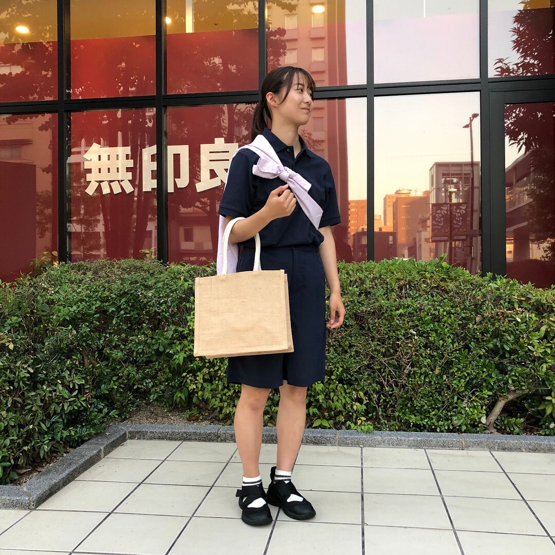 女の人がポロシャツを着て立っている写真