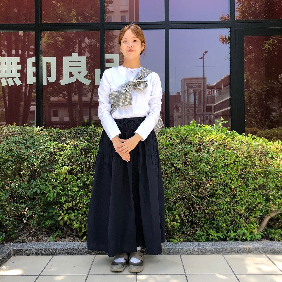 女性がスカートをはいて立っている写真