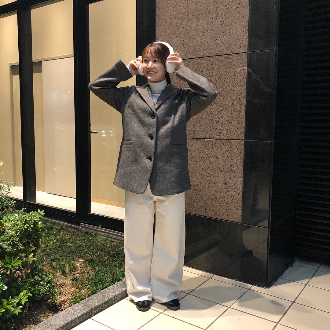女性がコートを着て立ってる写真