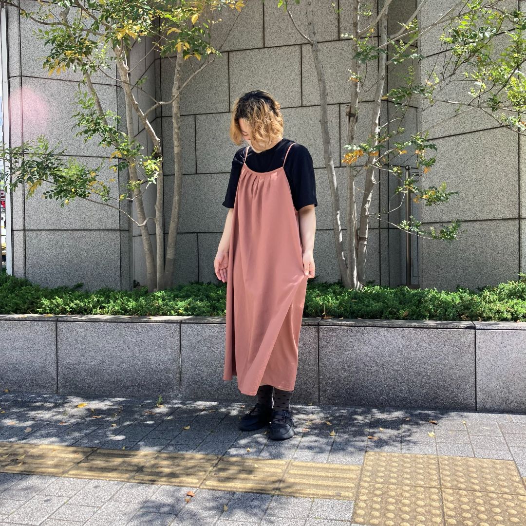 オレンジ色のキャミワンピースを着た女性