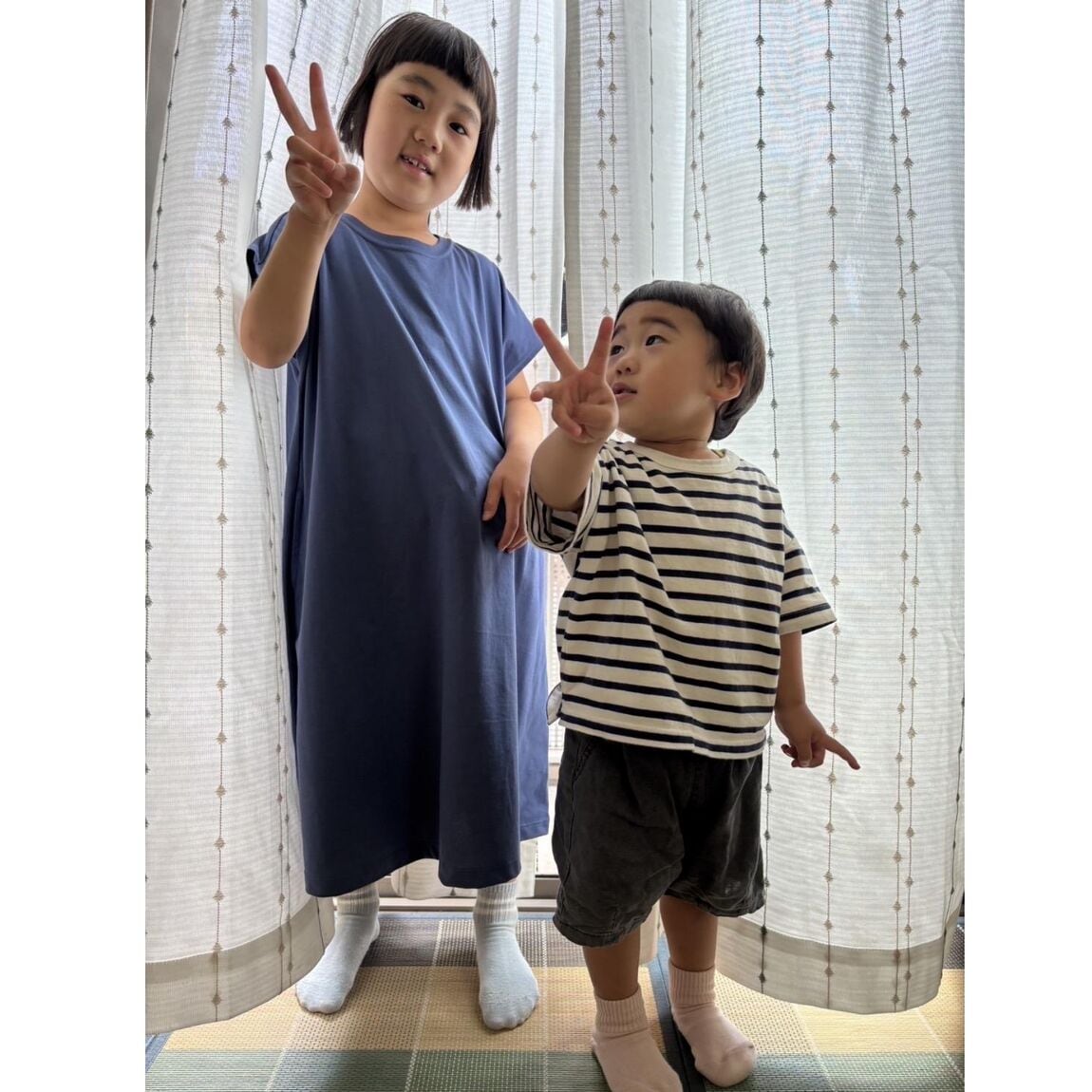 女の子と男の子の姉弟が並んでピースしてる写真