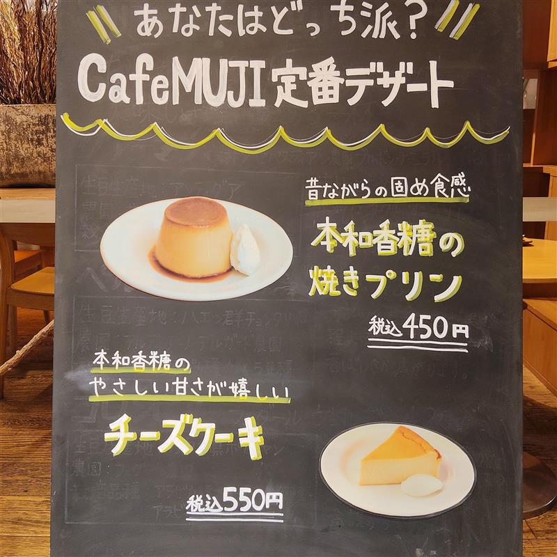 「あなたはどっち派？ カフェムジ定番デザート　本和香糖の焼きプリン450円、チーズケーキ550円」と書かれた黒板