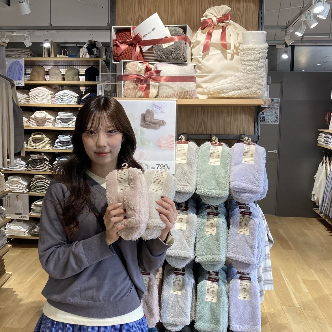 売り場の前でルームソックスを持っている女性
