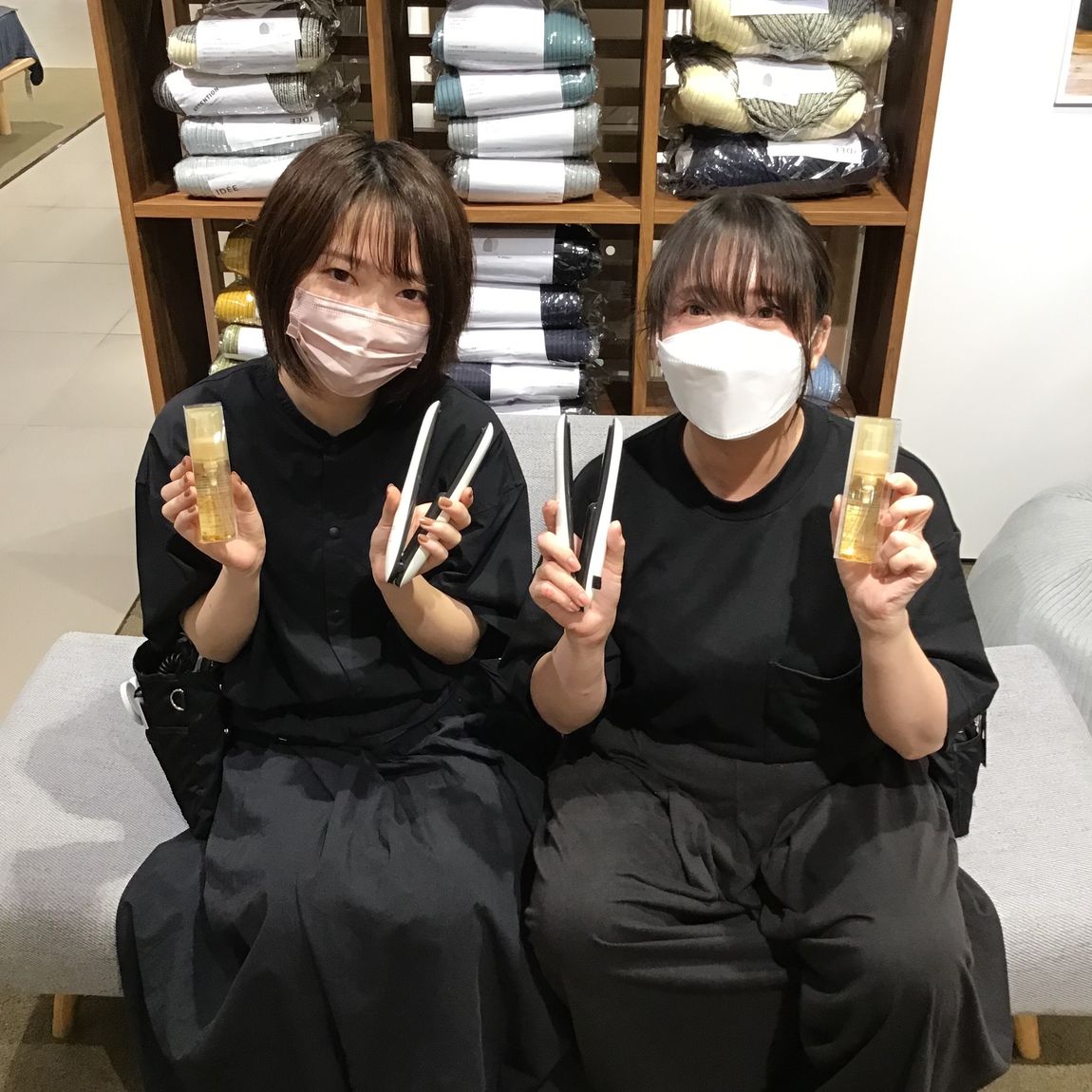 トラベル用ヘアストレートアイロンとヘアセラムを持つ2人