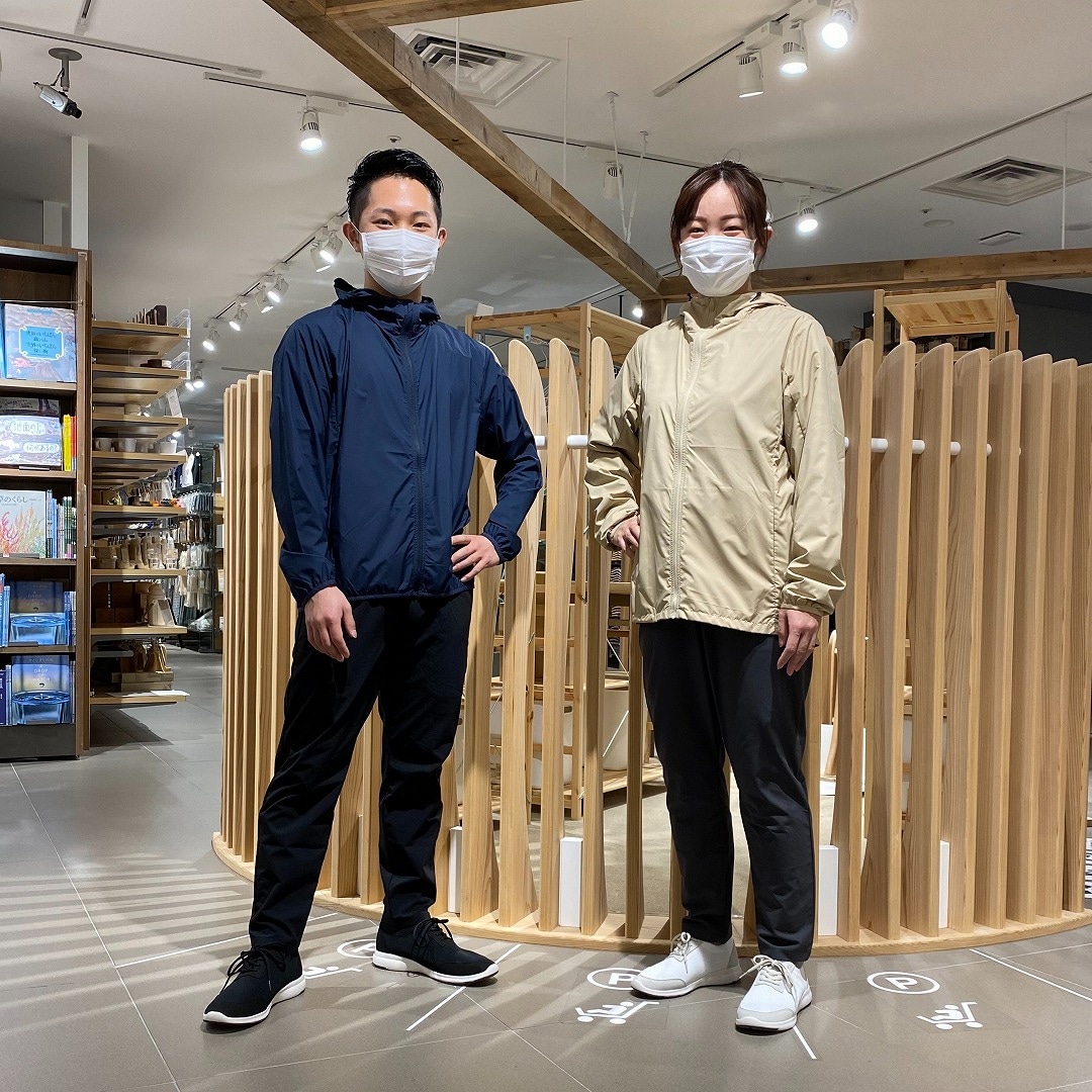 MUJI WALKERを着て男女のスタッフが立っている写真
