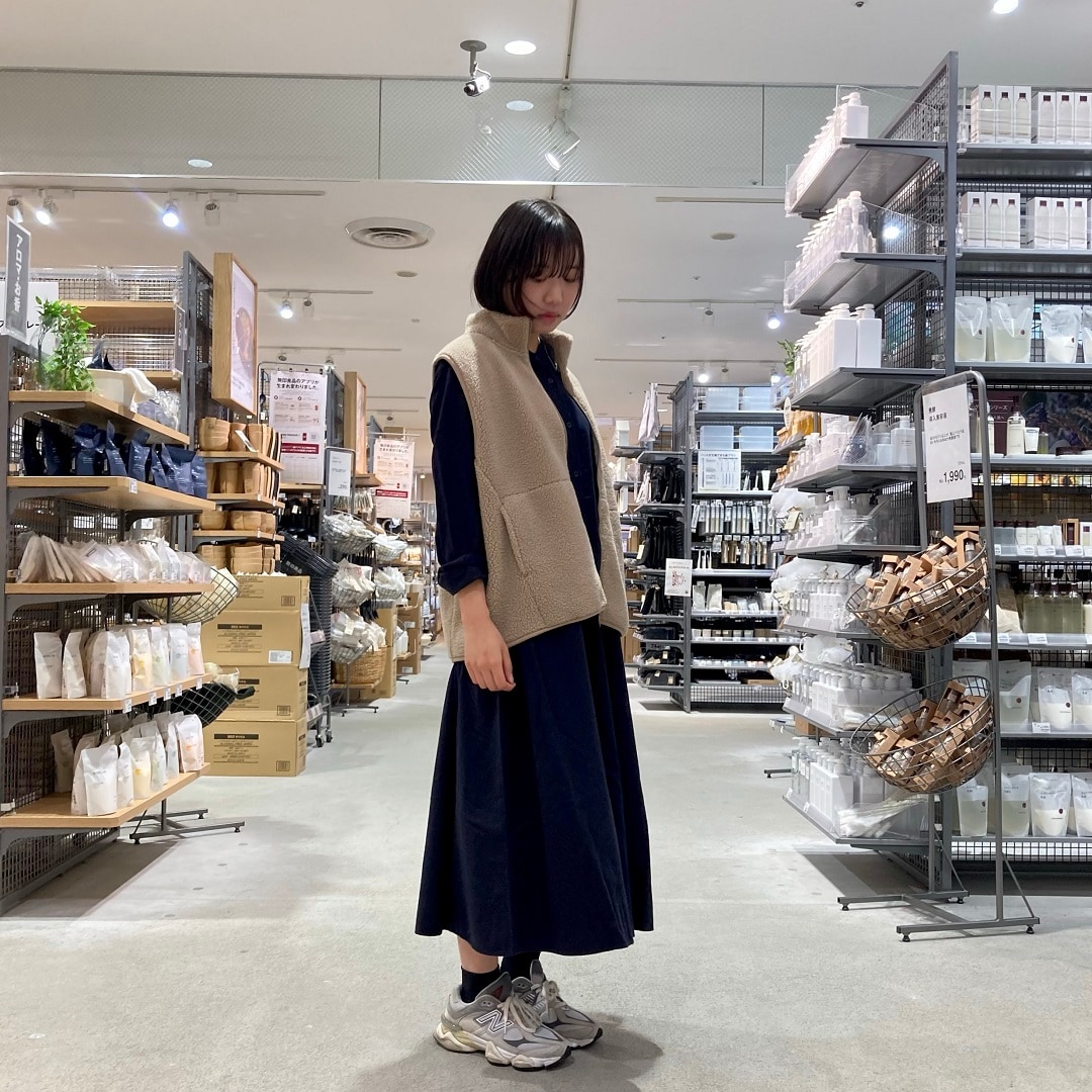 【イオンスタイル河辺】フランネルワンピースとボアベストを着たスタッフの右向きの写真