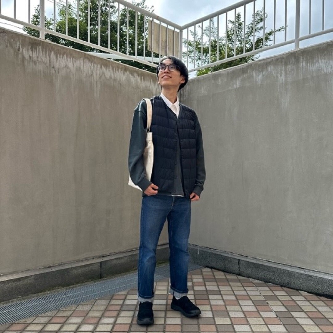ノーカラーベストを着る男性スタッフ
