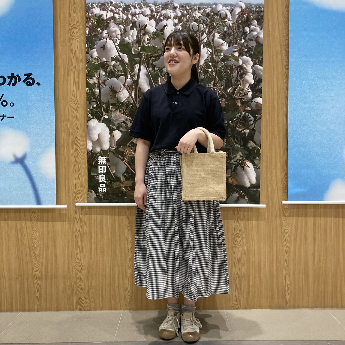 黒いシャツとチェックのスカートを身につけた女性スタッフの写真