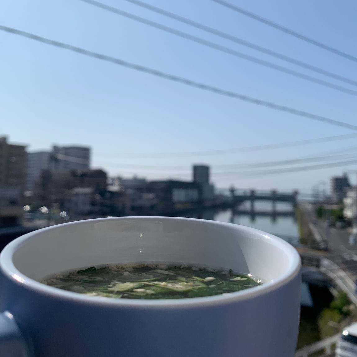 朝日を見つめながらスープを一杯飲む様子。