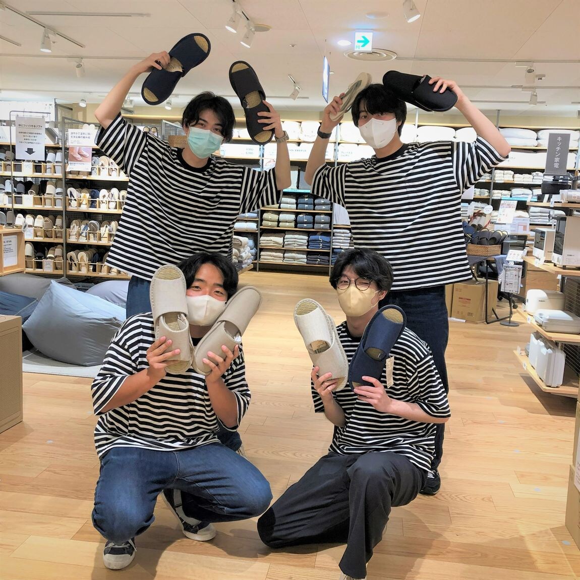男性スタッフ４人がスリッパを持っている写真
