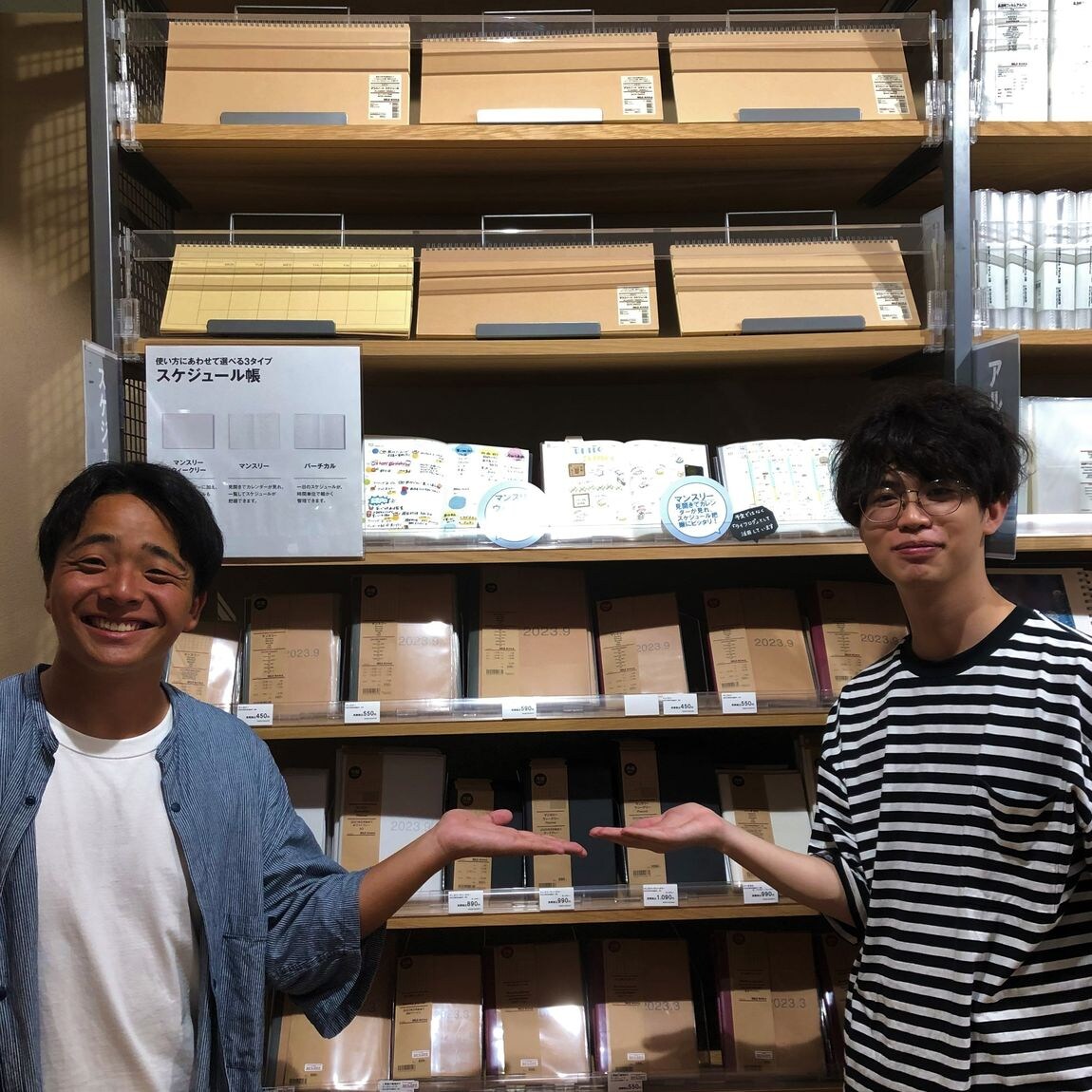 スタッフがスケジュールの売場の前で商品を紹介している様子