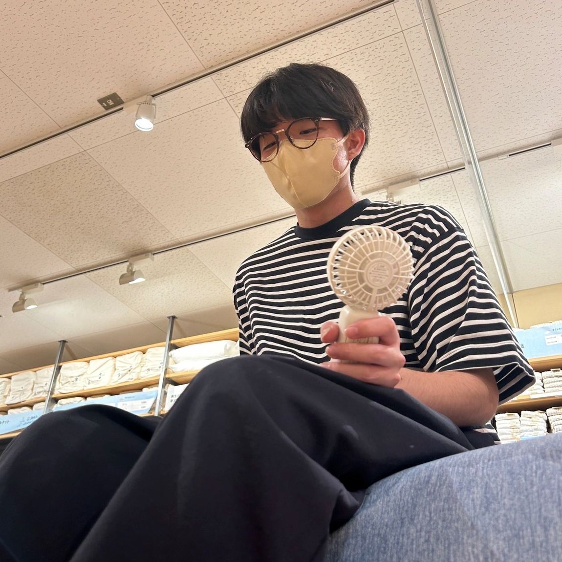 スタッフがひんやりシリーズの寝具のベッドの上に座っている様子