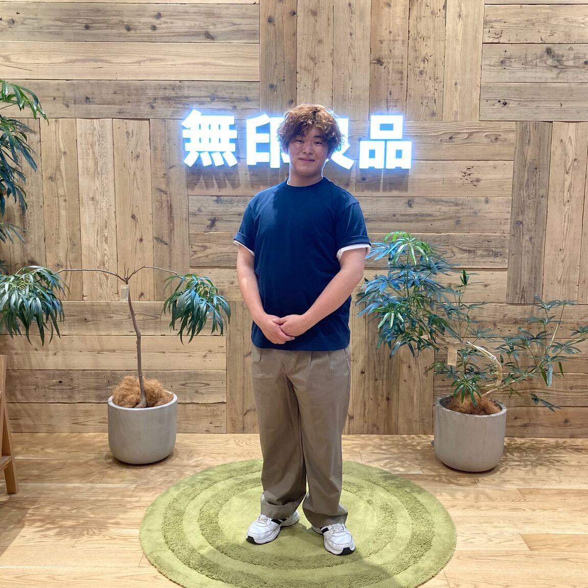 ネイビーのTシャツを着て立つ男性