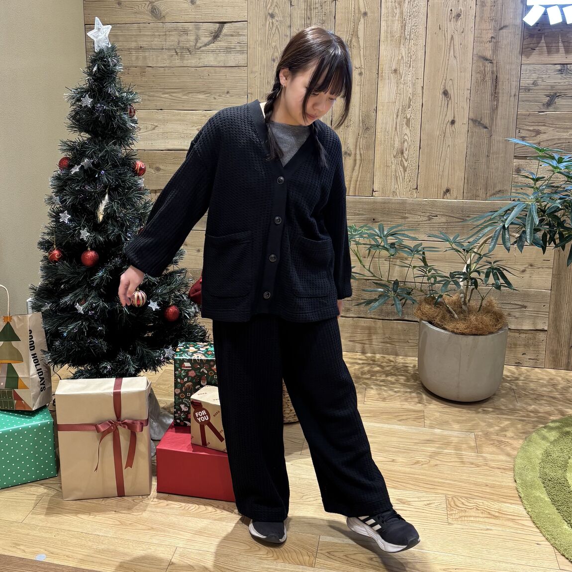 黒のセットアップのルームウェアを着て立つ女性