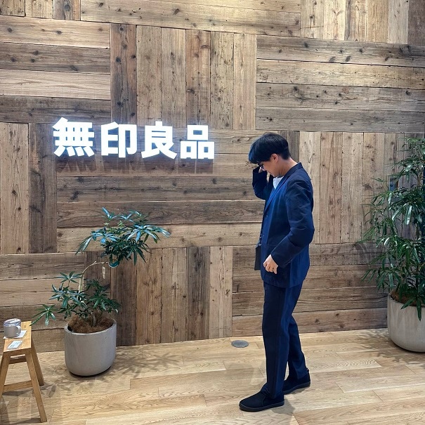 ネイビーのセットアップを着て立つ男性