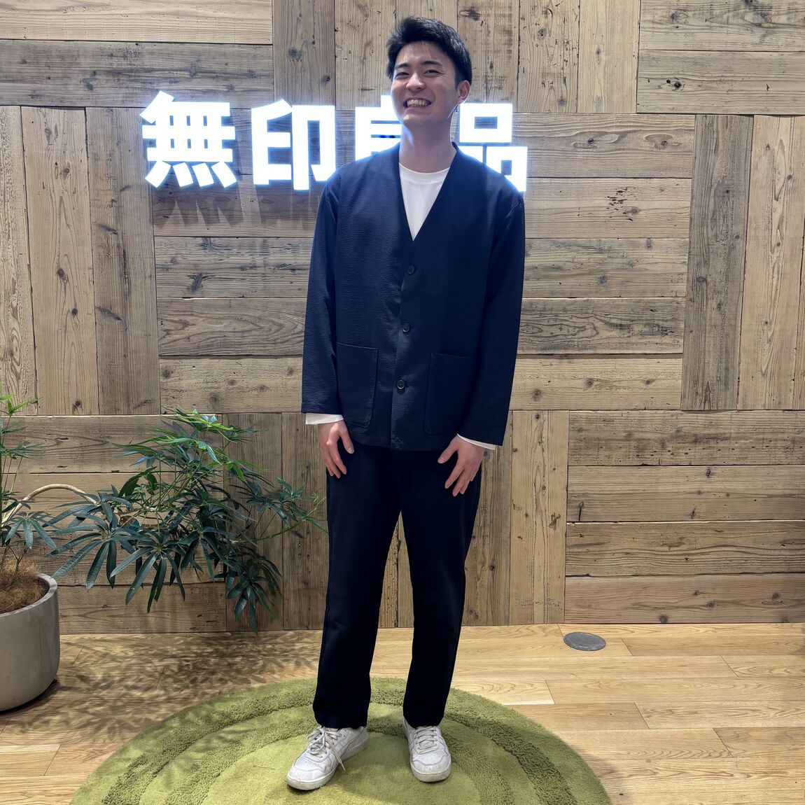 ネイビーのセットアップを着て立つ男性