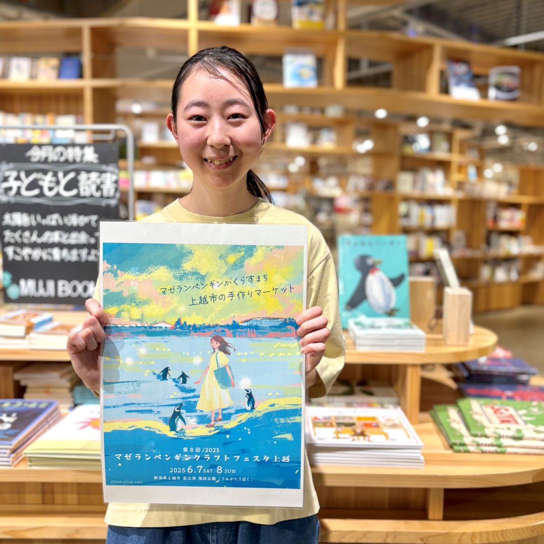 イベントポスターを持つ笑顔のスタッフ