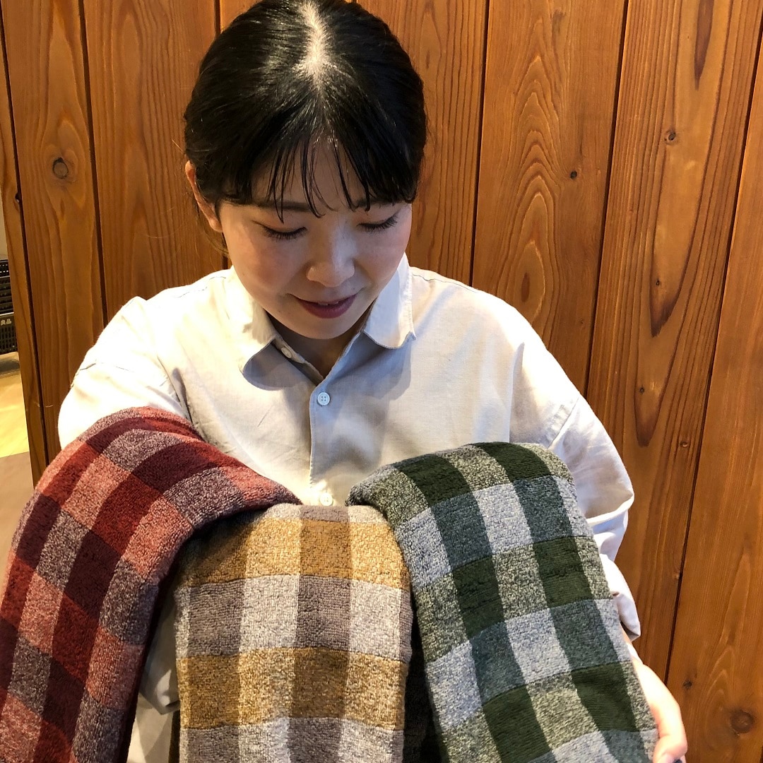 新色のタオルを持つ女性