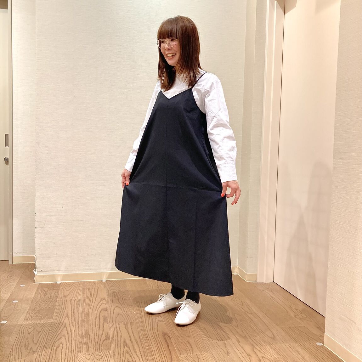 白のブラウスとくろのワンピースを着用した女性