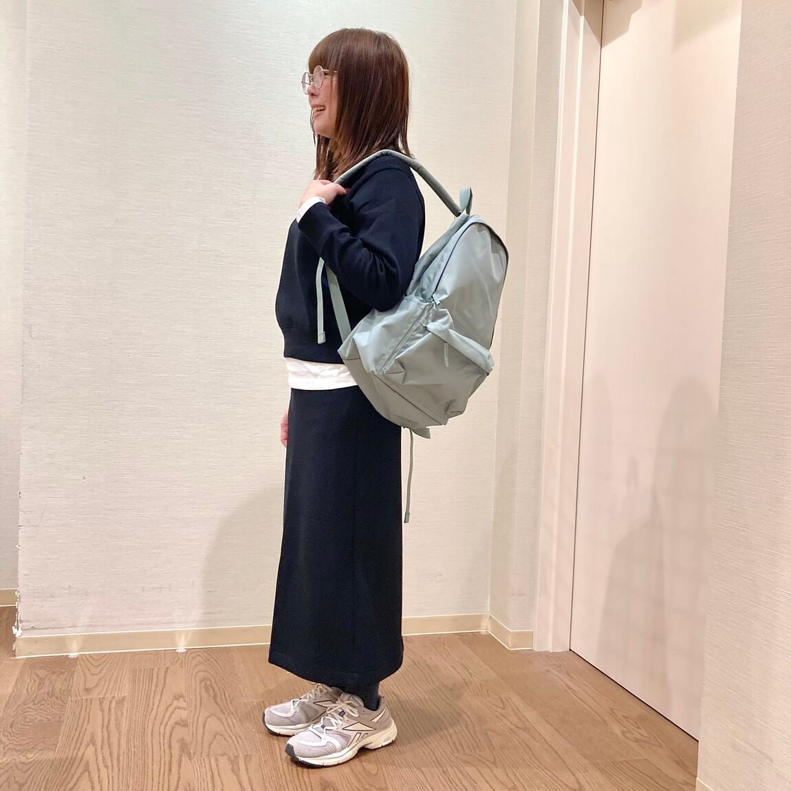 黒いスウェットのトップスとスカートを着用した女性