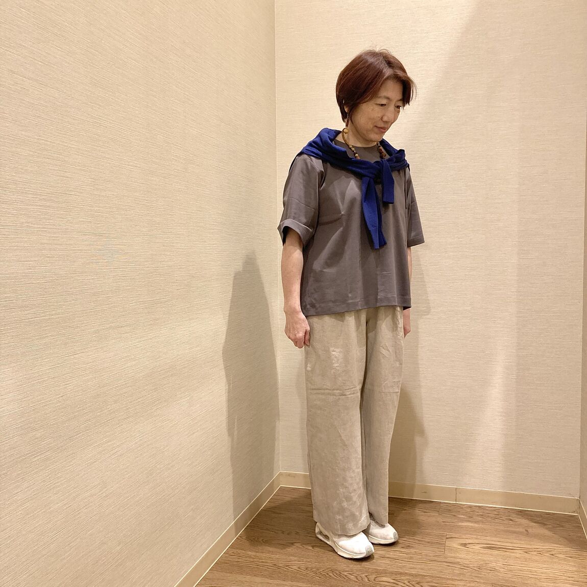 グレーのTシャツとベージュのパンツを着用した女性