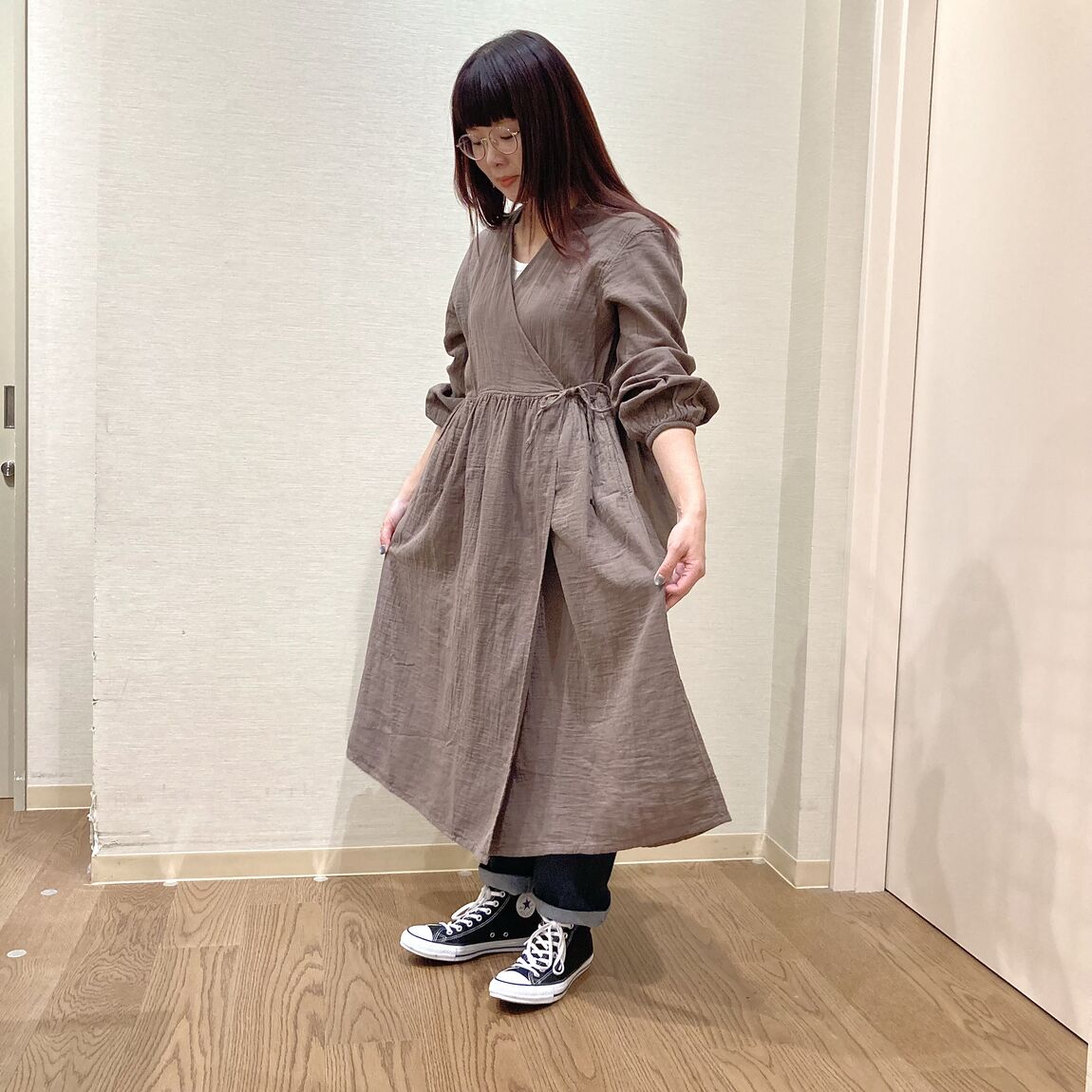 ブラウンのカシュクールワンピースを着用した女性