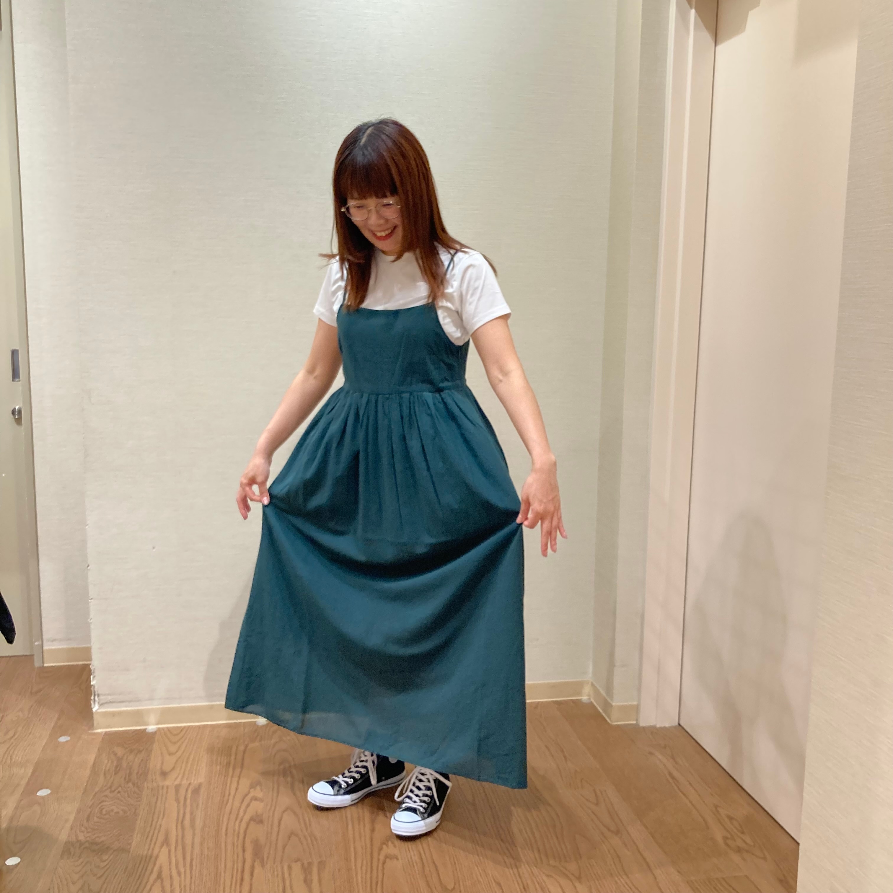 グリーンのキャミソールワンピースを着用した女性