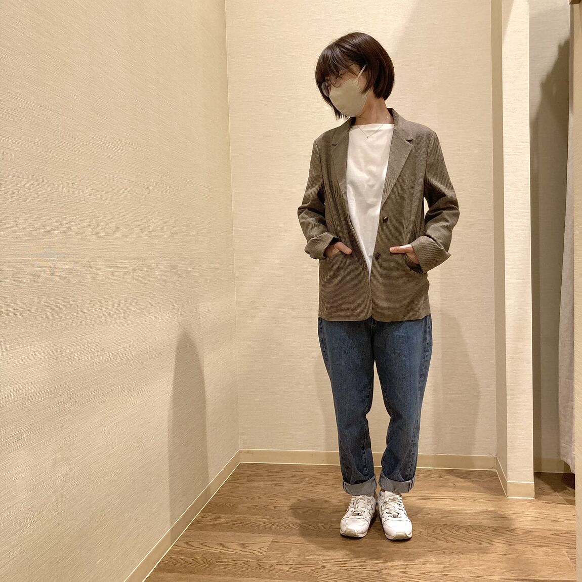 ジャケットにデニムパンツを着用した女性