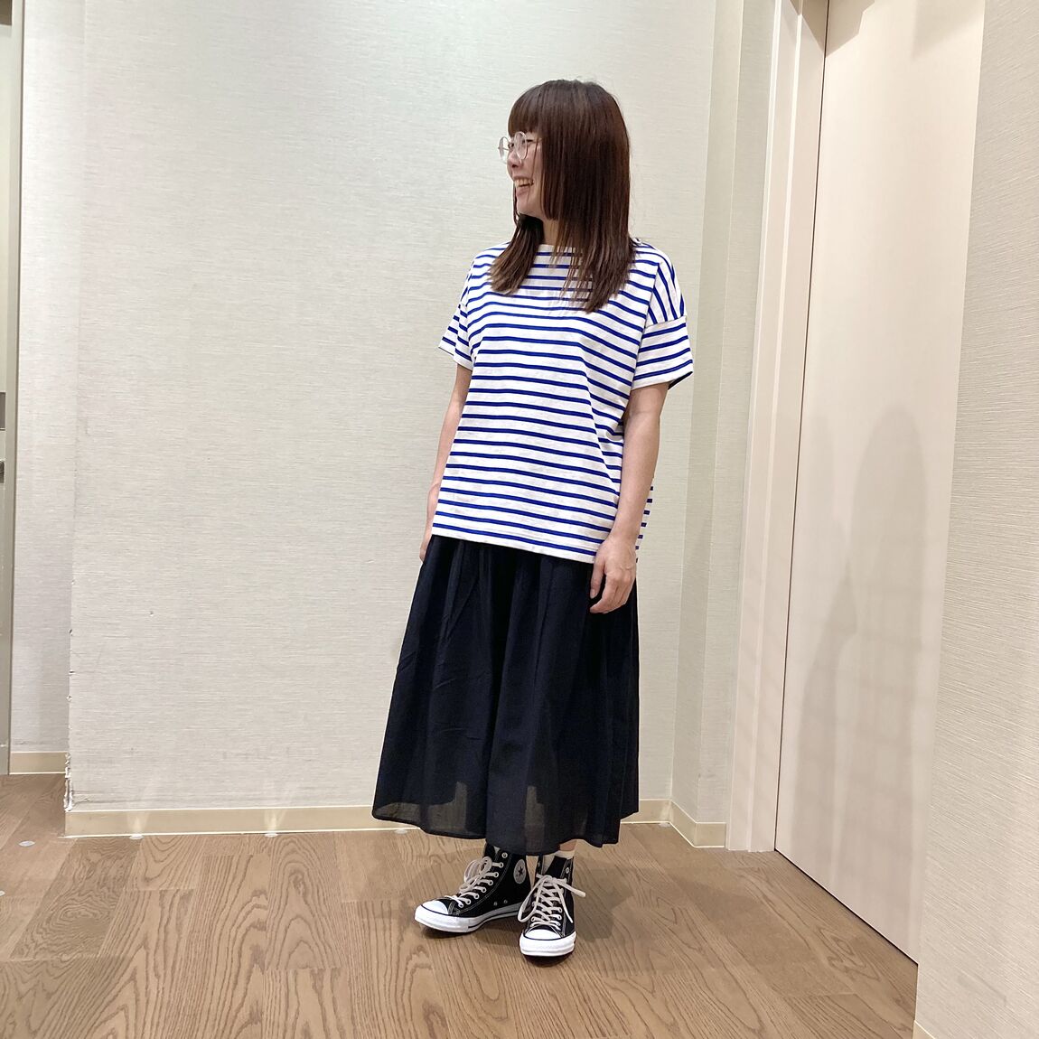 ボーダーのTシャツと黒のスカートを着用した女性