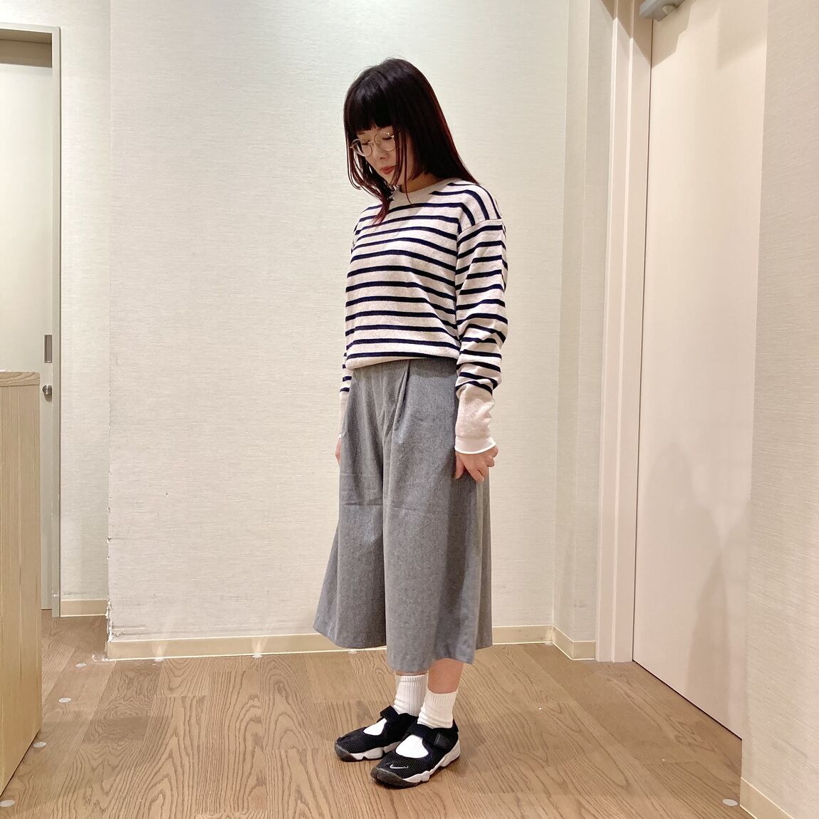 ボーダーのニットとキュロットスカートを着用した女性