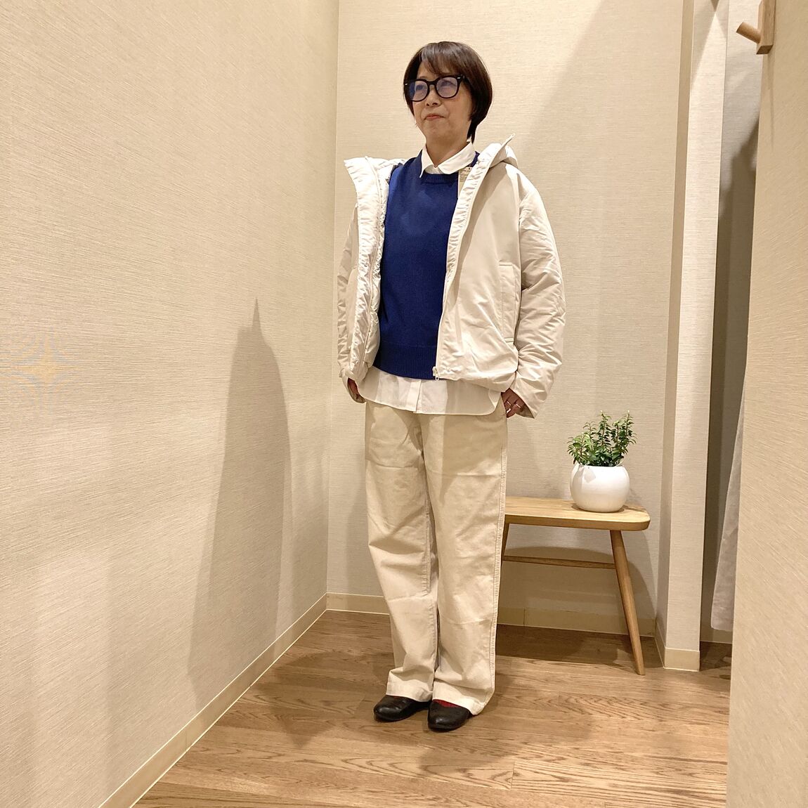 ブルーのセーターと白のダウンジャケットを着用したじ