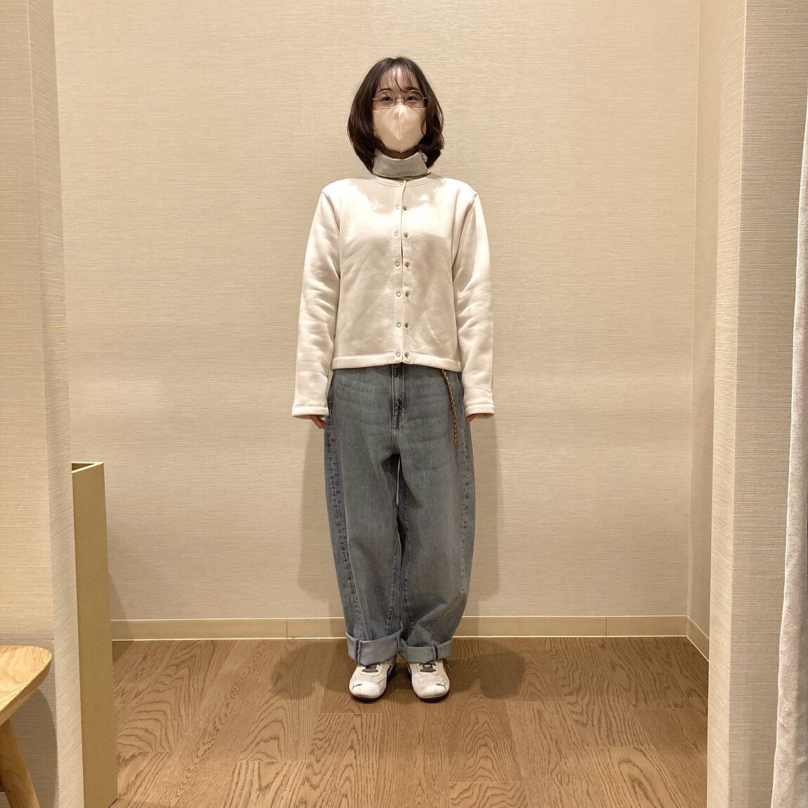 白いスウェットカーディガンとデニムを着用した女性