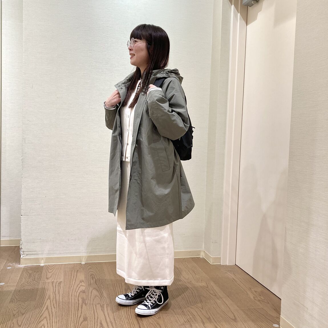 カーキのロングジャケットを着用した女性