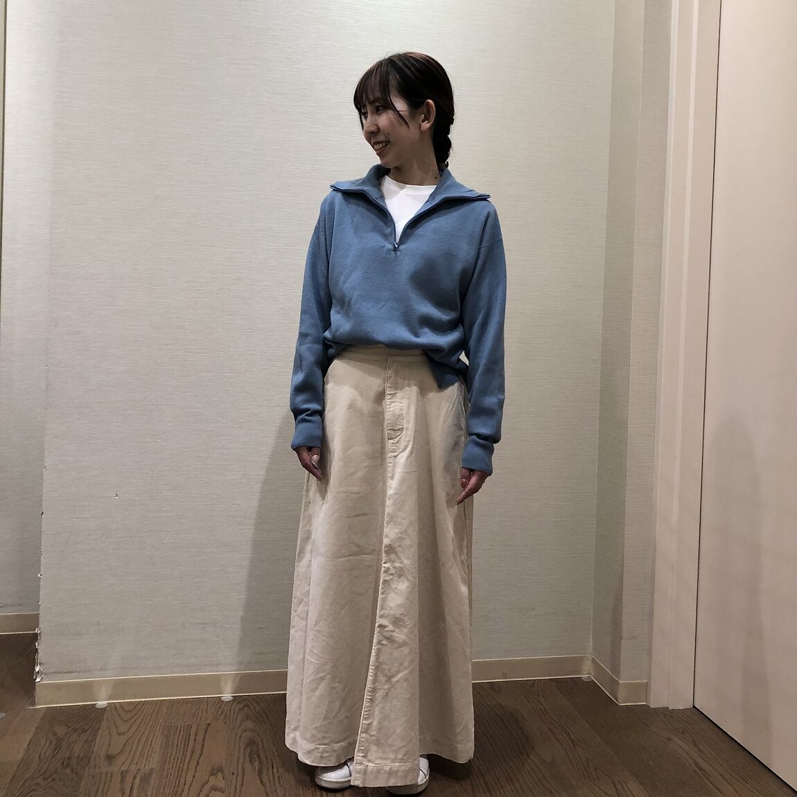 ブルーのセーターと白いスカートを着用した女性