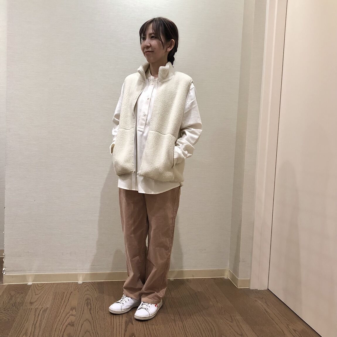 白いボアフリースベストを着用ささた女性