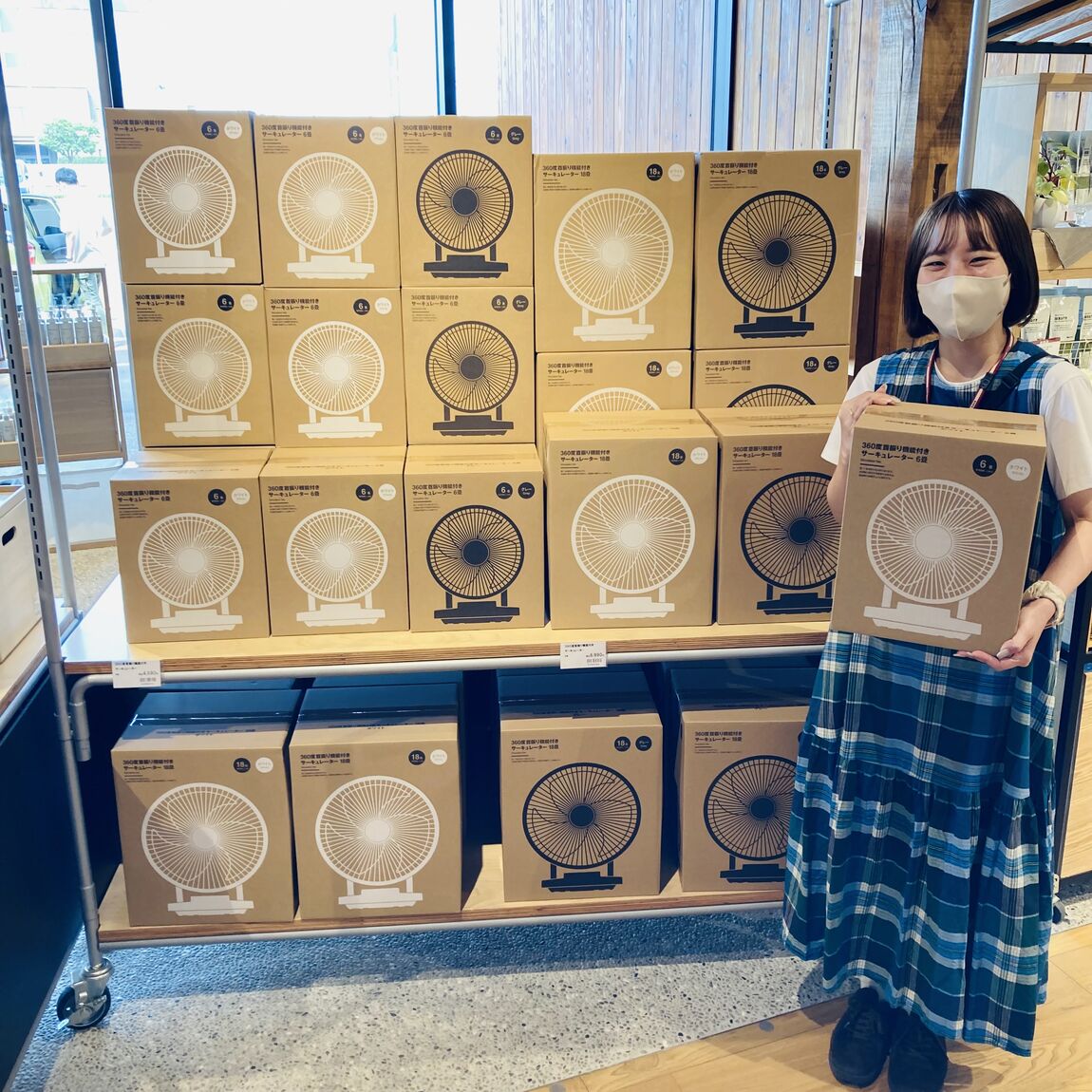 サーキュレーターを持ったスタッフが微笑んでいる