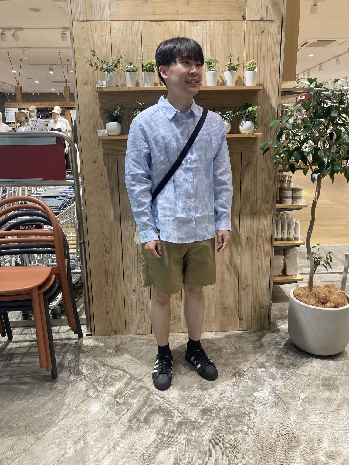 ベージュハーフパンツとブルーシャツを着る